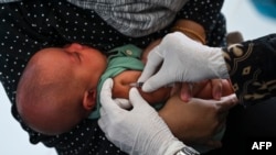 FILE - A baby receives a tuberculosis vaccine during a national immunization for children program at an integrated services post in Banda Aceh, Indonesia, on June 9, 2022.