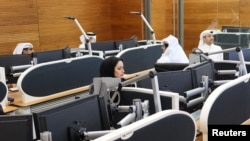 FILE - Qatari diplomats work inside an operation room set up to coordinate the truce and release of hostages between Israel and the Palestinian Islamist group Hamas, at the National Command Centre in Doha, Nov. 26, 2023.