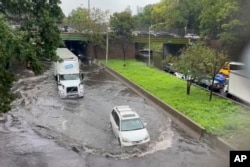 In this photo taken from video, traffic makes its way through flood waters along the Brooklyn Queens Expressway in New York, Sept. 29, 2023.