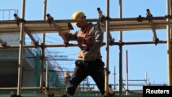 2024年1月26日，一名建筑工人站在北京一处工地的脚手架上。（路透社照片）
