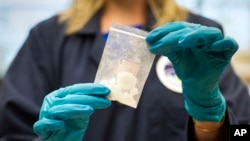 FILE - A bag of 4-fluoro isobutyryl fentanyl that was seized in a drug raid is displayed at the Drug Enforcement Administration Special Testing and Research Laboratory in Sterling, Va., Aug. 9, 2016.