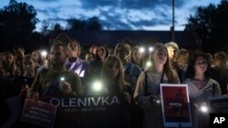 People hold signs as they gather outside the Russian Embassy in Kyiv, Ukraine, July 29, 2023, to mark one-year anniversary of the attack on a prison building in Olenivka, eastern Ukraine, that killed dozens of Ukrainian military prisoners.