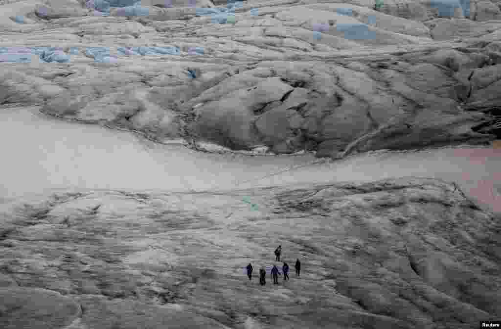 Hikers cross Boverbreen glacier, an inland glacier in Jotunheimen National Park near Lom, Norway, July 22, 2023.