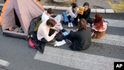 University students rest on a key traffic alley in downtown Belgrade, Serbia, Dec. 29, 2023, during their protest after reported irregularities in a recent election.