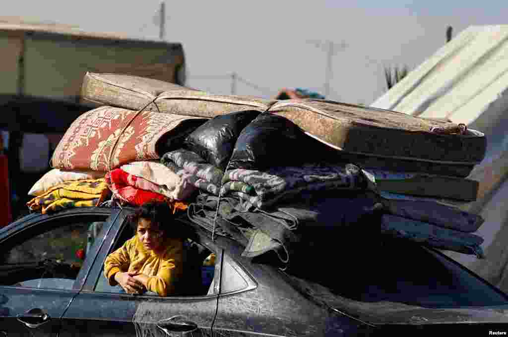 A person looks out from a car window as displaced Palestinians, who fled their houses due to Israeli strikes, shelter in a tent camp, in Rafah in the southern Gaza Strip.