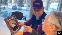 George Kudrin, left, and Pauline Golodoff hold a photo of Pauline and her late husband, Gregory Golodoff, in Anchorage, Alaska, Dec. 1, 2023.