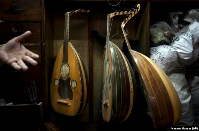 FILE - In this Tuesday, Jan. 8, 2013 photo, Egyptian musical instrument specialist and piano tuner Khadr Dagher, 65, unseen, speaks about the musical instrument known as an oud at his shop, in downtown Cairo, Egypt. (AP Photo/Nasser Nasser)