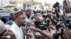 Ousmane Sonko parle aux journalistes alors que son convoi s'arrête sur le chemin de son procès à Dakar, le 16 mars 2023.