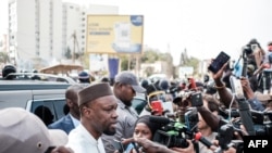 FILE: Ousmane Sonko speaks to reporters as his convoy stops on the way to his trial in Dakar on March 16, 2023. -