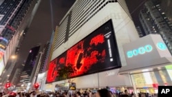 In this undated image released by Art Innovation Gallery, Patrick Amadon's "No Rioters" digital artwork is seen on the billboard of the SOGO shopping mall in Hong Kong.