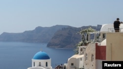 FILE - Tourists visit Oia, on the island of Santorini, Greece, Aug. 31, 2022.