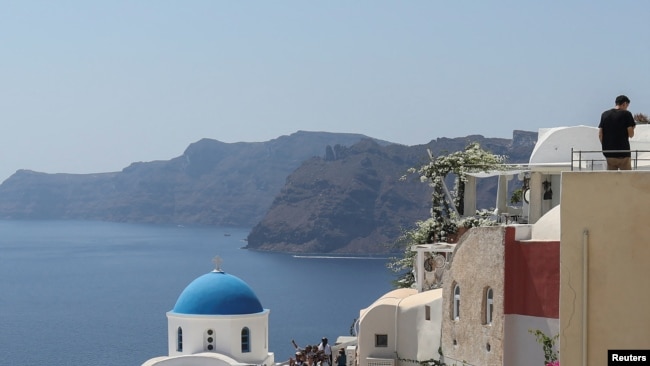 FILE - Tourists visit Oia, on the island of Santorini, Greece, Aug. 31, 2022.