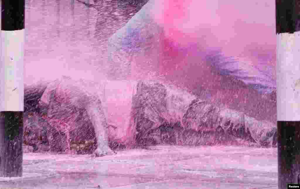 A man falls after police use water cannon to disperse protesters during a demonstration against Kenya&#39;s proposed finance bill 2024/2025 in Nairobi.