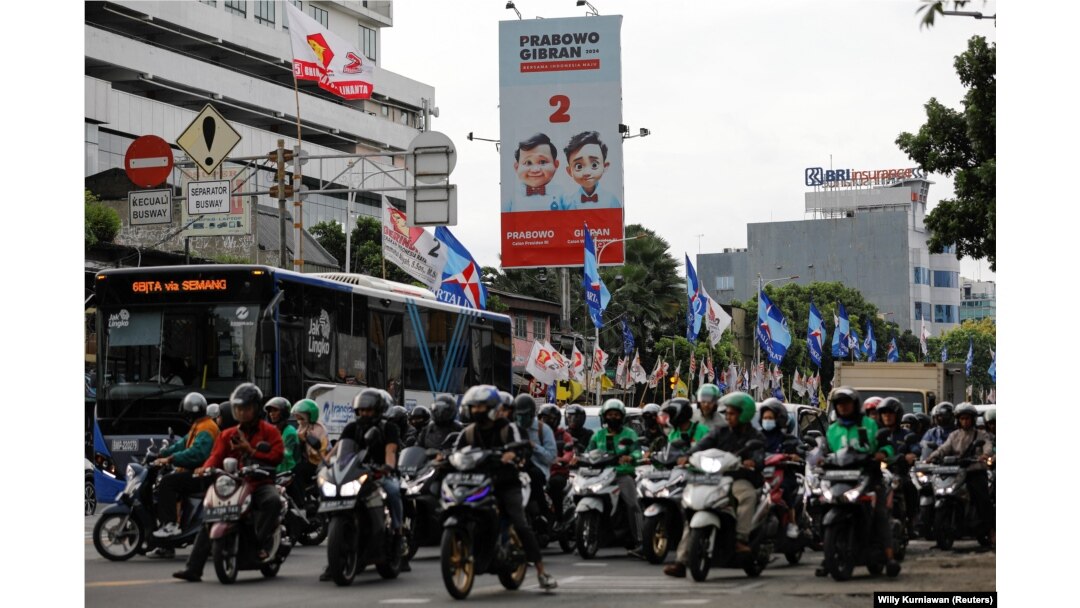 Masyarakat berjalan melewati baliho Menteri Pertahanan dan calon Presiden Prabowo Subianto dan pasangannya Gibran Rakabuming Raka di Jakarta, 12 Januari 2024. (Foto: REUTERS/Willy Kurniawan)