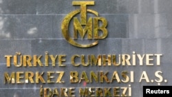 Logo Bank Sentral Turki terlihat di pintu masuk kantor pusatnya di Ankara, Turki 15 Oktober 2021. (REUTERS/Cagla Gurdogan)