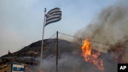Flames engulf a hill on the Aegean Sea island of Rhodes, southeastern Greece, July 24, 2023. 