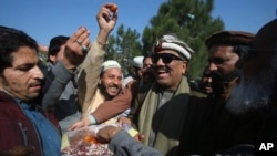 Malik Tariq Awan, center right, an independent candidate, celebrates with supporters after his victory in the parliamentary elections, in Peshawar, Pakistan, Feb. 9, 2024.