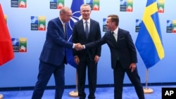 2023年7月10日，土耳其总统埃尔多安（左）与瑞典首相克里斯特森（右）握手，北约秘书长斯托尔滕贝格站在中间。（美联社照片）