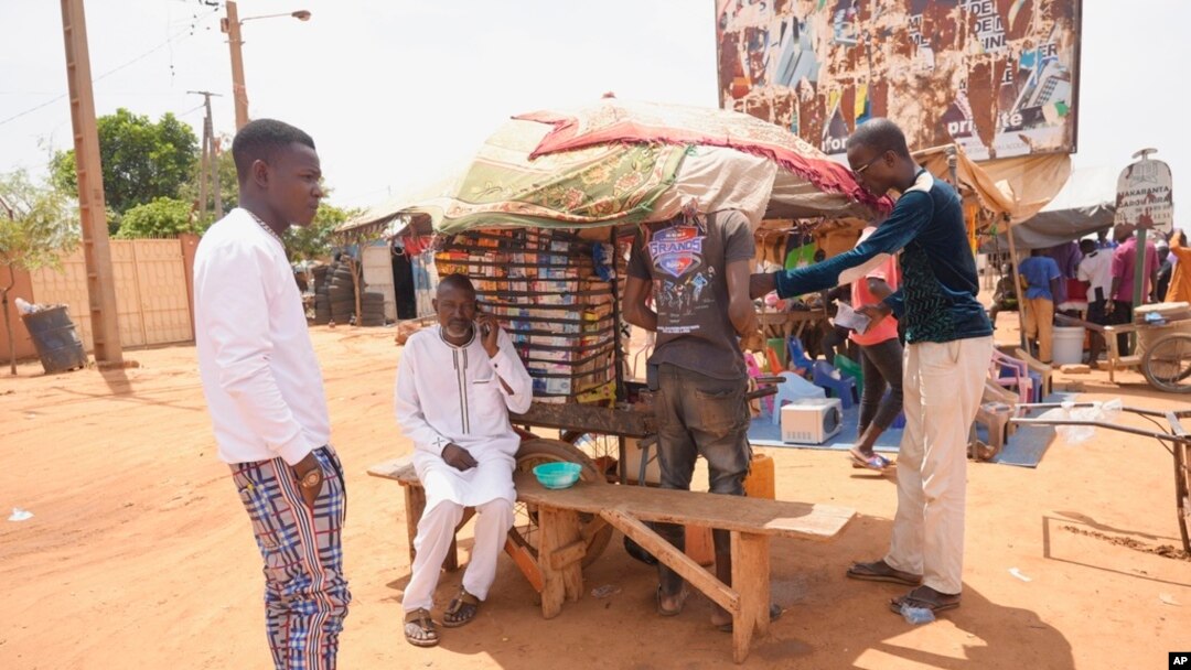 Men stand in a street side market in Niamey, Niger, July 29, 2023. 