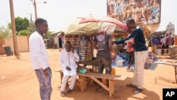 Men stand in a street side market in Niamey, Niger, July 29, 2023. 