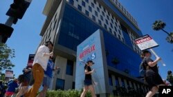 Los manifestantes llevan carteles afuera de Netflix durante un mitin del Sindicato de Escritores el jueves 13 de julio de 2023 en Los Ángeles. (Foto AP/Mark J. Terrill)