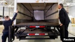 Police officers open the back of the truck used in the heist after authorities gave details of the arrests made a year after 6,600 gold bars and nearly $2 million in cash were stolen from Toronto Pearson International Airport, April 17, 2024.