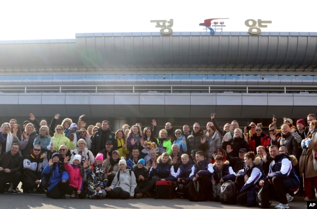 A group of Russian tourists, likely the first foreign travelers from any country to enter North Korea since the pandemic pose for a group photo on the arrival at the Pyongyang International Airport in Pyongyang, North Korea, Feb. 9, 2024.