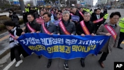 Doctors march toward the presidential office during a rally against the government's medical policy in Seoul, South Korea, Sunday, Feb. 25, 2024. (AP Photo/Ahn Young-joon)