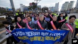 Doctors march toward the presidential office during a rally against the government's medical policy in Seoul, South Korea, Feb. 25, 2024.