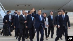 FILE- Former Taiwan President Ma Ying-jeou, center, waves as he arrivers with a delegation at the Pudong airport in Shanghai, China, March 27, 2023.