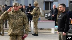 Un militar saluda después de que el presidente ucraniano, Volodymyr Zelenskyy, le otorgara una medalla en Okhtyrka, en la región de Sumy, Ucrania, el 28 de marzo de 2023.