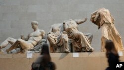 Visitors walk past sculptures that are part of the Parthenon Marbles at the British Museum in London, Nov. 28, 2023. 