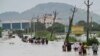 People, many carrying their belongings, wade through a flooded road after heavy rains in Vijayawada, India, Sept. 2, 2024. 