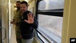 Ukrainian President Volodymyr Zelenskyy waves goodbye after an interview with The Associated Press on a train traveling from the Sumy region to Kyiv, Ukraine, March 28, 2023.