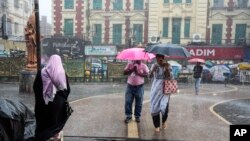 কলকাতায় বৃষ্টির মধ্যে হাঁটছে মানুষ। 