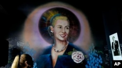 FILE - A mural of Argentine former first lady Eva Perón, or Evita, depicting her with a saint's halo, adorns a wall inside the Peron Peron restaurant in the San Telmo neighborhood of Buenos Aires, Argentina, Feb. 9, 2024. 