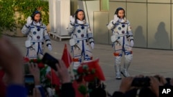 Chinese astronauts for the Shenzhou-17 mission, from left, Jiang Xinlin, Tang Hongbo and Tang Shengjie wave as they arrive for a send-off ceremony for their manned space mission, Oct. 26, 2023.