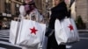 FILE - Sejumlah konsumen menenteng tas belanja Macy's saat hari belanja 'Black Friday" di New York, 24 November 2023. Ekonomi Amerika Serikat tumbuh lebih kuat dari proyeksi pada Kuartal-II 2024 ditopang konsumsi dalam negeri yang kuat. (Foto: Yuki Iwamura/AFP)