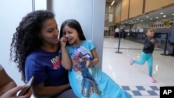 Karen Malavé, izquierda, inmigrante venezolana, y sus hijas, en una comisaría de policía de Chicago, el 1 de mayo de 2023.