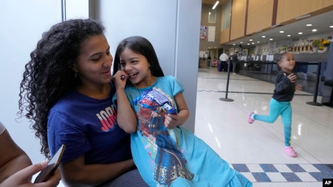 Karen Malave, left, an immigrant from Venezuela, and her daughters, at a Chicago Police station, May 1, 2023.