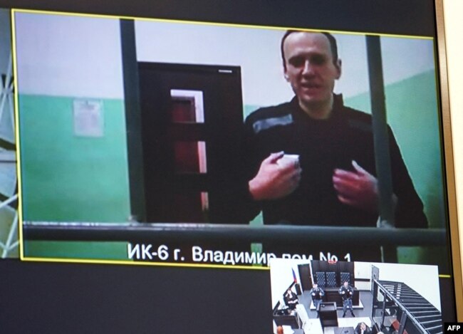 FILE - A screen shows jailed Kremlin critic Alexey Navalny as he arrives at a court in Moscow, on Sept. 26, 2023.