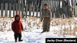 (FILE) North Korean children stand after snowfall along the banks of the Yalu River.