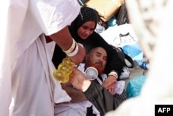 A man effected by the scorching heat is helped by others as Muslim pilgrims arrive to perform the symbolic 'stoning of the devil' ritual as part of the hajj pilgrimage in Mina, near Saudi Arabia's holy city of Mecca, June 16, 2024.