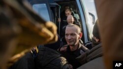 FILE - Swapped Ukrainian prisoners of war arrive by bus after a prisoner exchange, at an unidentified location in Ukraine, Jan. 31, 2024.