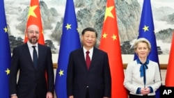 In this photo released by Xinhua News Agency, Chinese President Xi Jinping, center, stands with European Commission President Ursula von der Leyen and European Council President Charles Michel in Beijing, Dec. 7, 2023.