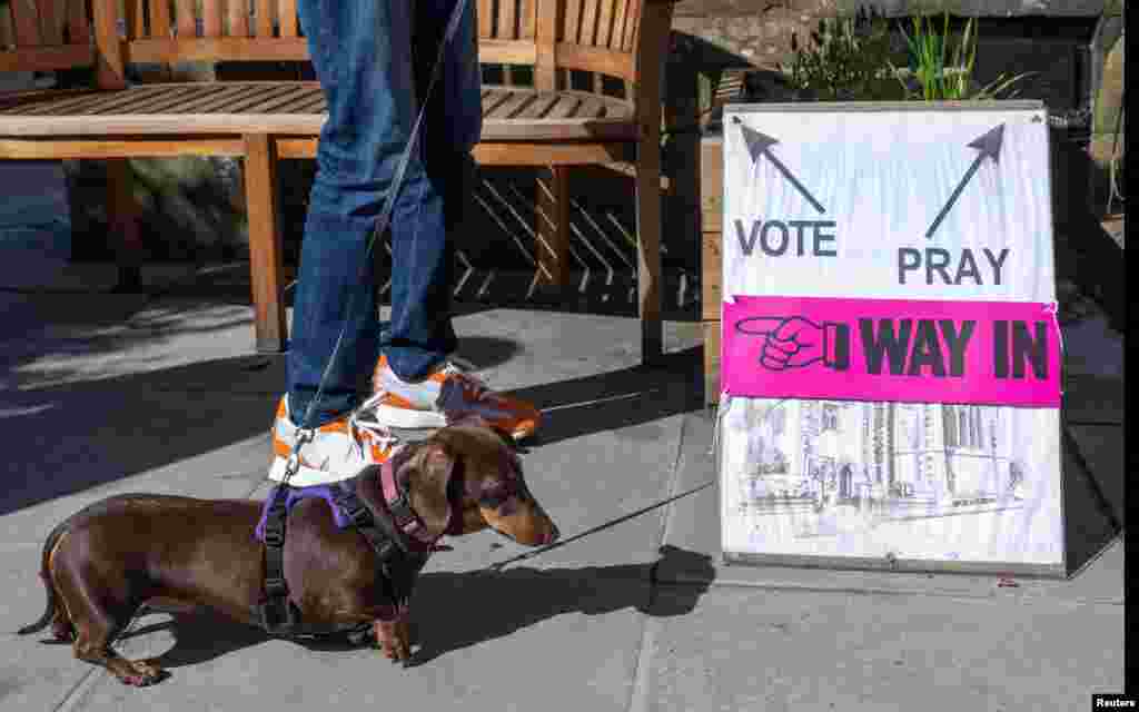 A person and a dog wait outside St James&#39; Church polling station during the general election in Edinburgh, Scotland, Britain.