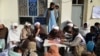 FILE - Afghan refugees deported from Pakistan wait to receive food aid by the Red Cross Society in Kandahar, Afghanistan, on Jan. 24, 2024.