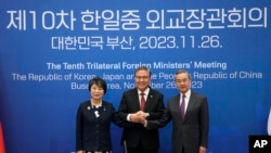 2023年11月26日，中國外交部長王毅（右）、南韓外長樸振（中）和日本外相上川洋子在韓國釜山舉行的三方外交部長會議前合影留念。（美聯社照片）