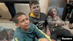 Palestinians children wounded in Israeli strikes wait to be assisted at Nasser hospital in Khan Younis in the southern Gaza Strip, Dec. 7, 2023.