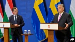 Sweden's Prime Minister Ulf Kristersson, left, listens to his Hungarian counterpart Viktor Orban during a press conference at the Carmelite Monastery in Budapest, Hungary, Feb 23, 2024.